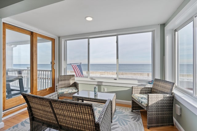 sunroom / solarium with a beach view and a water view