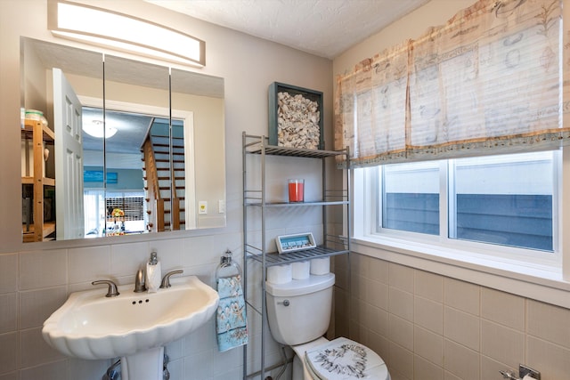 bathroom featuring a healthy amount of sunlight, sink, a textured ceiling, and toilet