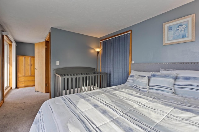 bedroom with light colored carpet and a textured ceiling