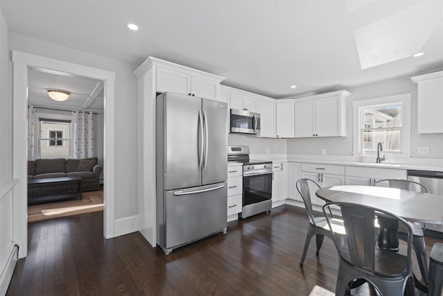 kitchen with dark hardwood / wood-style flooring, sink, white cabinets, and appliances with stainless steel finishes