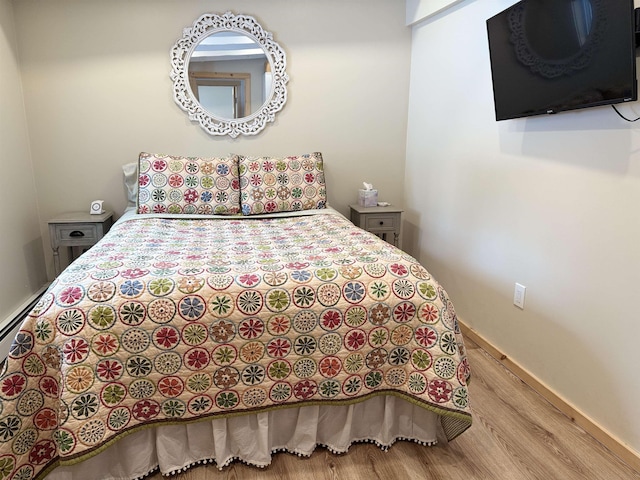 bedroom featuring a baseboard radiator and light wood-type flooring