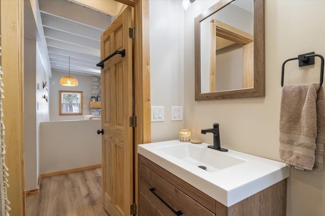 bathroom featuring vanity, hardwood / wood-style floors, and beam ceiling