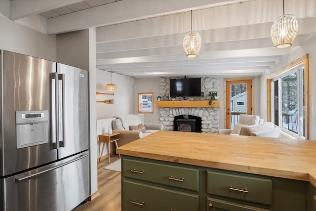 kitchen with decorative light fixtures, stainless steel fridge, beamed ceiling, and green cabinets