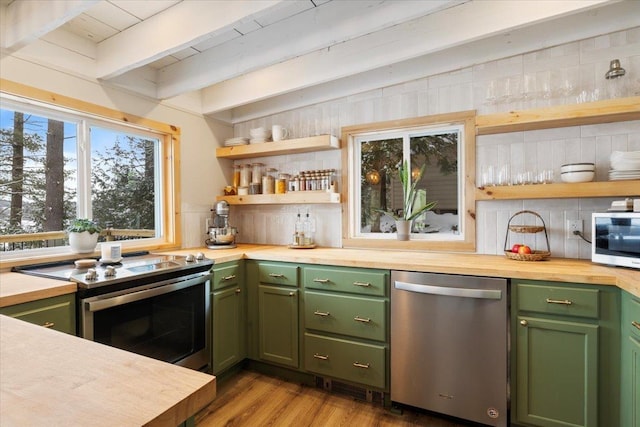 kitchen featuring appliances with stainless steel finishes, butcher block countertops, backsplash, green cabinets, and beam ceiling