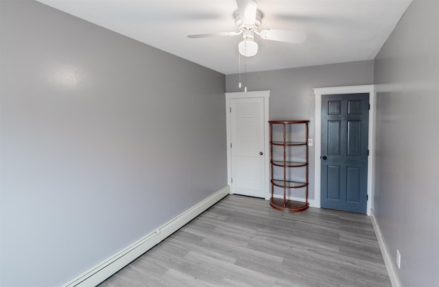 spare room featuring ceiling fan, a baseboard radiator, and light wood-type flooring