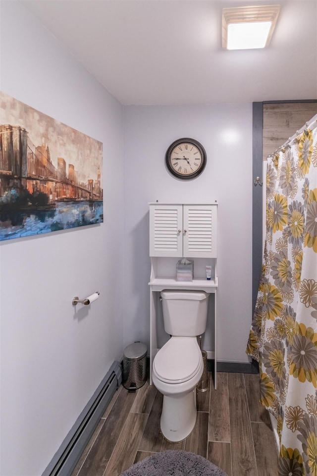 bathroom with a shower with curtain, a baseboard heating unit, and toilet