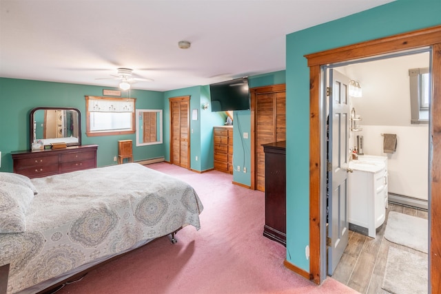 bedroom featuring multiple closets, ceiling fan, and baseboard heating