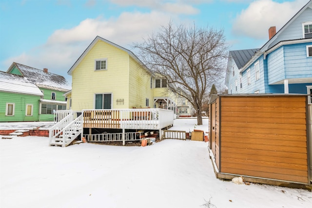 snow covered house featuring a wooden deck