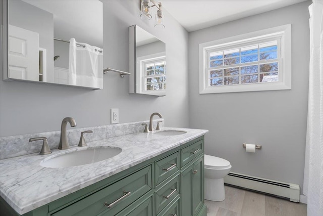 bathroom with vanity, hardwood / wood-style floors, a baseboard radiator, and toilet