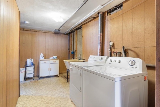 laundry room featuring washer and dryer and wood walls