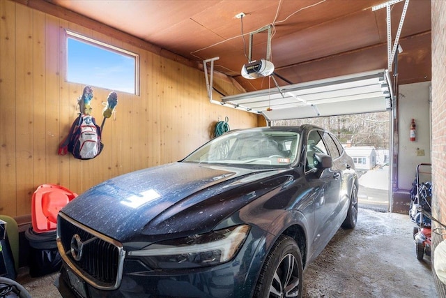 garage featuring a garage door opener and wood walls