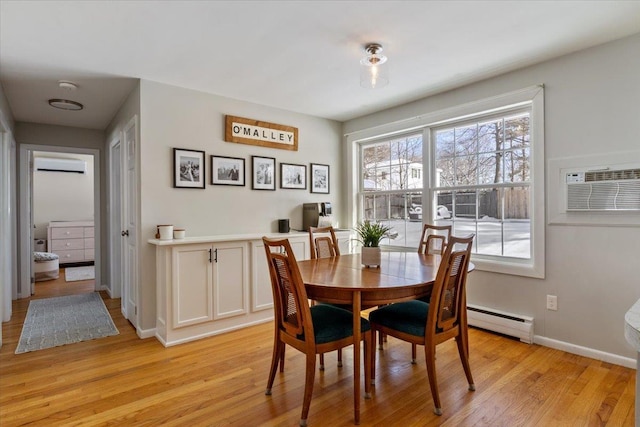 dining area with a wall mounted air conditioner, baseboard heating, and light hardwood / wood-style flooring