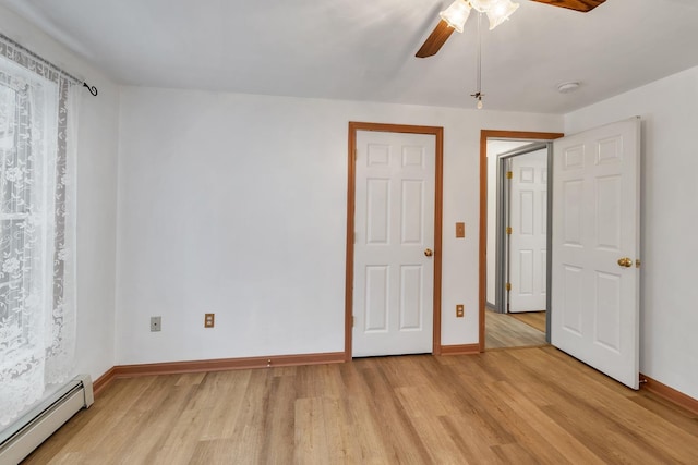 unfurnished bedroom featuring light hardwood / wood-style flooring, a baseboard radiator, and ceiling fan