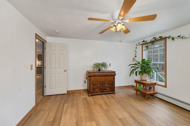 living area featuring ceiling fan, light hardwood / wood-style floors, and a baseboard heating unit