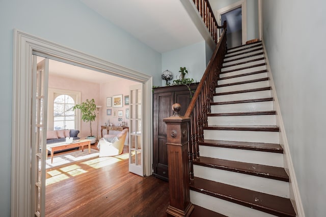 staircase featuring french doors and wood-type flooring