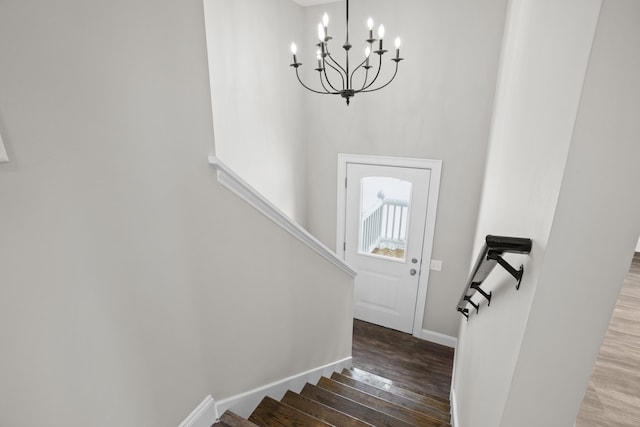 stairs featuring hardwood / wood-style flooring and a chandelier