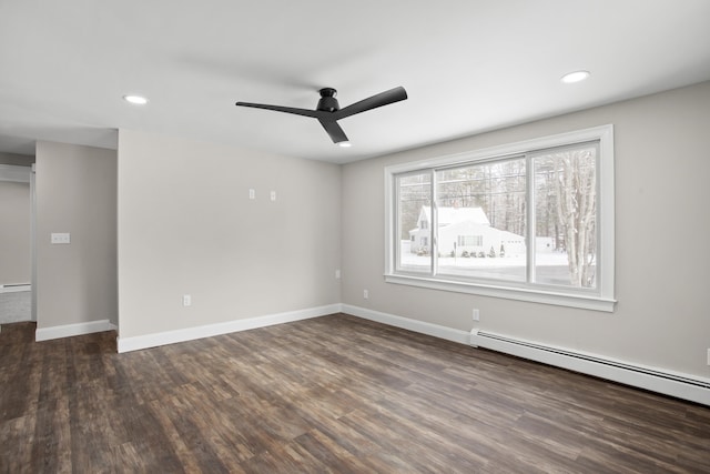 spare room featuring dark hardwood / wood-style floors, ceiling fan, and baseboard heating