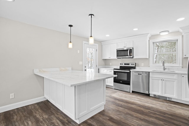 kitchen featuring sink, appliances with stainless steel finishes, light stone countertops, white cabinets, and kitchen peninsula