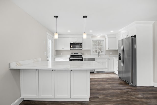 kitchen with white cabinetry, stainless steel appliances, and kitchen peninsula