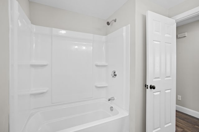 bathroom featuring wood-type flooring and  shower combination