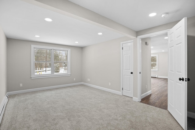 carpeted empty room featuring beamed ceiling, plenty of natural light, and baseboard heating