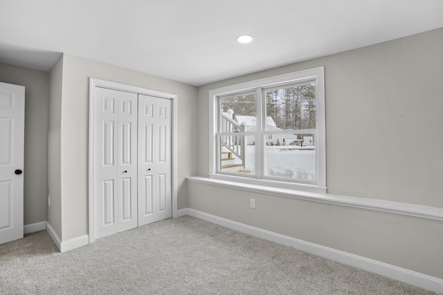 unfurnished bedroom featuring light carpet and a closet