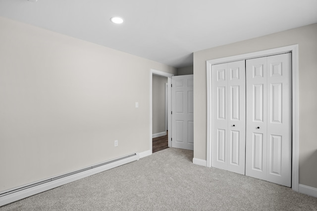 unfurnished bedroom with a baseboard radiator, light colored carpet, and a closet