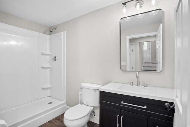 bathroom featuring vanity, toilet, wood-type flooring, and a shower