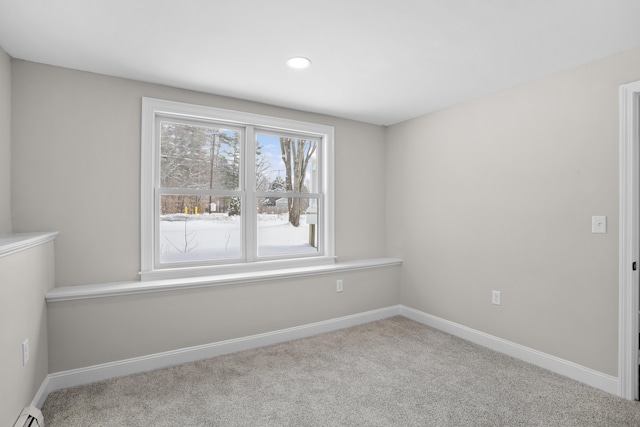 carpeted empty room featuring a baseboard heating unit