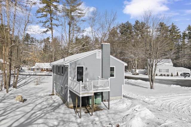 snow covered property with a wooden deck