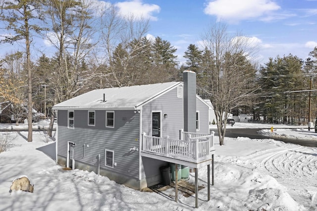 snow covered house with a wooden deck