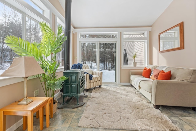 sunroom featuring vaulted ceiling and a wood stove