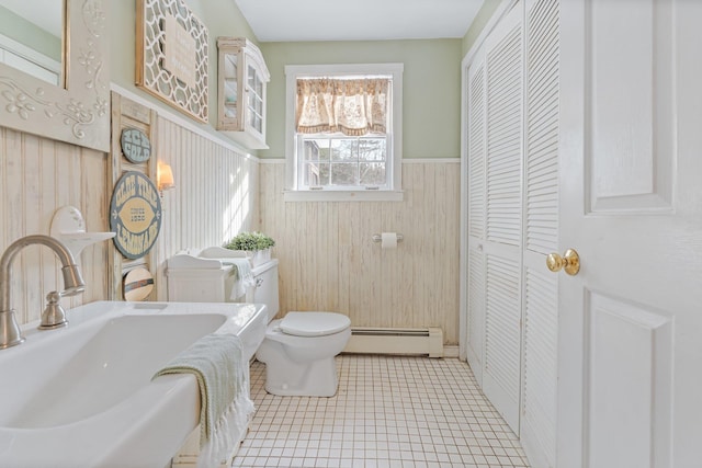 bathroom featuring tile patterned flooring, a baseboard radiator, sink, and toilet