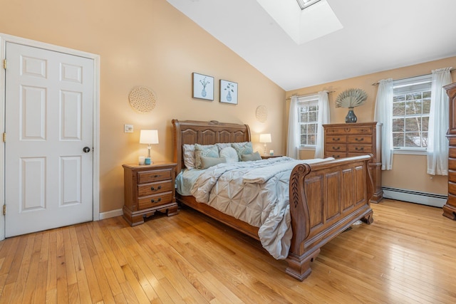 bedroom featuring light hardwood / wood-style flooring, lofted ceiling with skylight, and baseboard heating