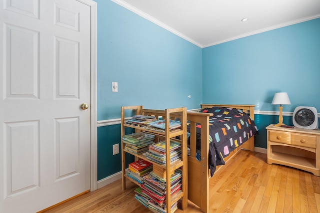 bedroom with crown molding and light hardwood / wood-style flooring