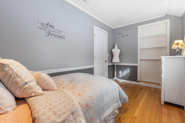 bedroom with lofted ceiling, ornamental molding, and light hardwood / wood-style flooring