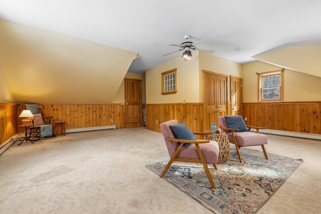 living area with lofted ceiling, carpet floors, wooden walls, and baseboard heating