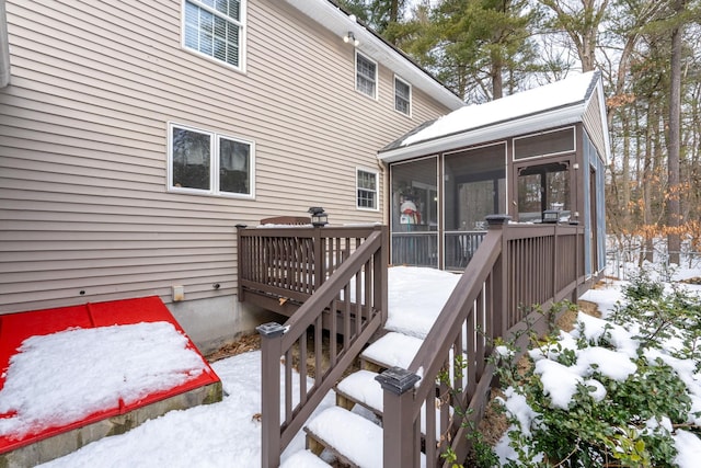 snow covered deck with a sunroom