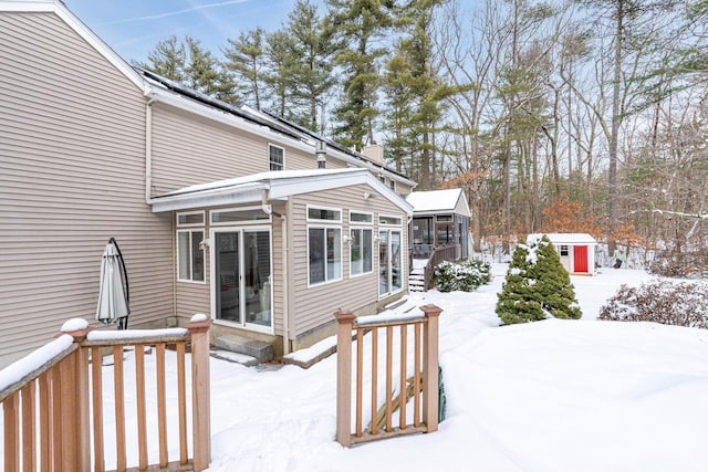 snow covered deck with a sunroom