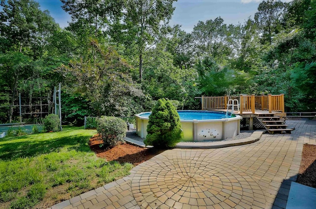 view of swimming pool featuring a patio area, a lawn, and a deck