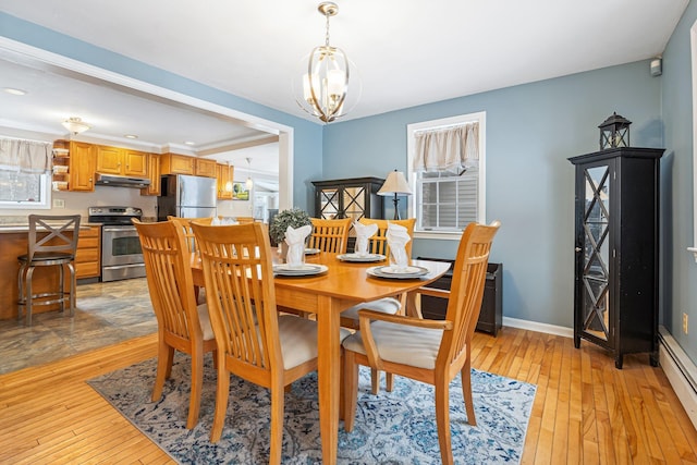 dining space featuring a baseboard radiator, light hardwood / wood-style flooring, and a notable chandelier