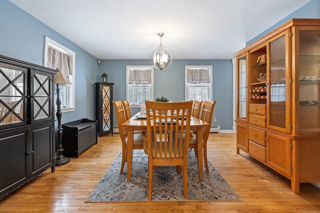 dining space featuring an inviting chandelier and light hardwood / wood-style floors