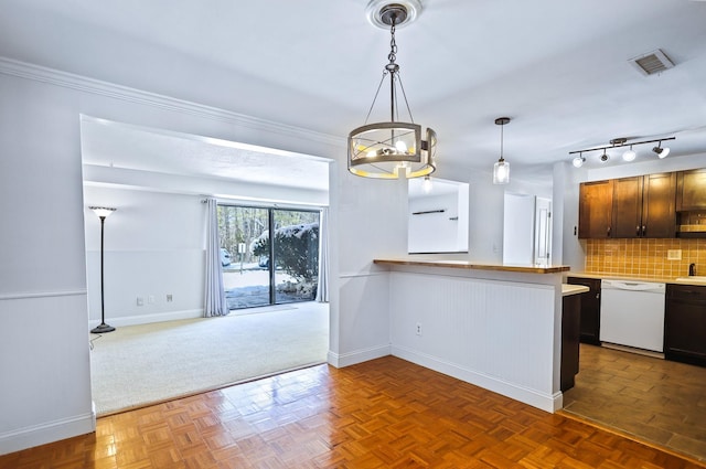 kitchen with dark parquet floors, dishwasher, hanging light fixtures, and kitchen peninsula