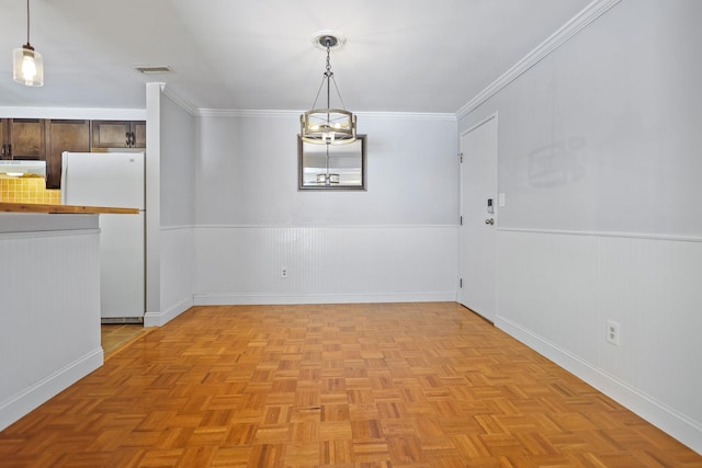 unfurnished dining area featuring ornamental molding and light parquet floors