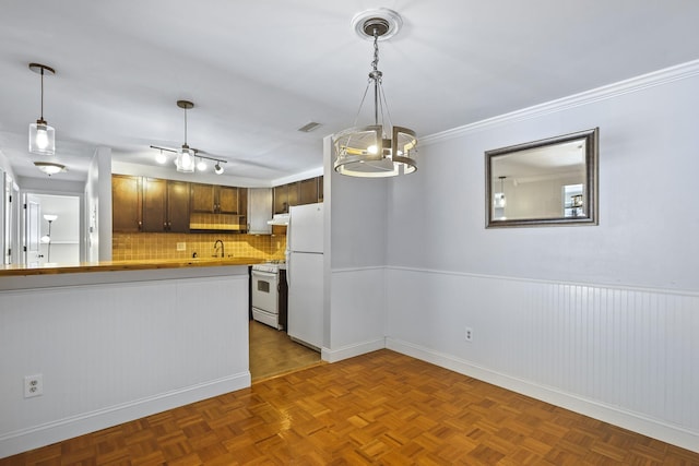 kitchen featuring dark parquet floors, sink, decorative backsplash, kitchen peninsula, and white appliances