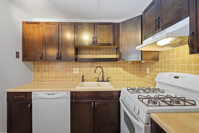 kitchen with dark brown cabinetry, sink, white appliances, and decorative backsplash