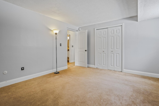 unfurnished bedroom with light carpet, a closet, and a textured ceiling