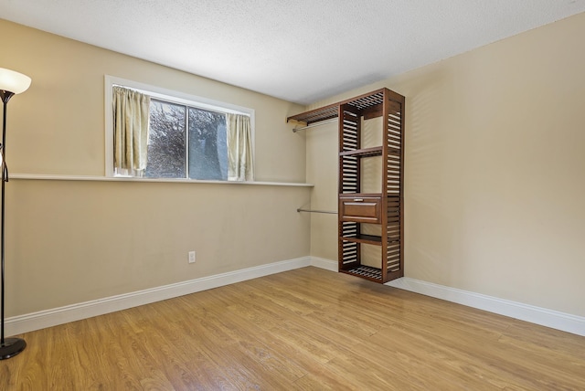 unfurnished bedroom with a textured ceiling and light wood-type flooring