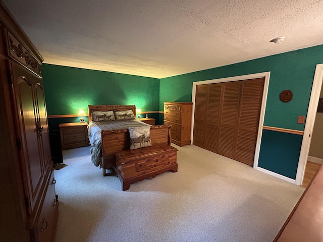 bedroom featuring light colored carpet, a textured ceiling, and a closet