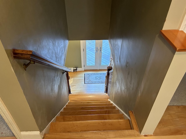 staircase with hardwood / wood-style flooring and french doors